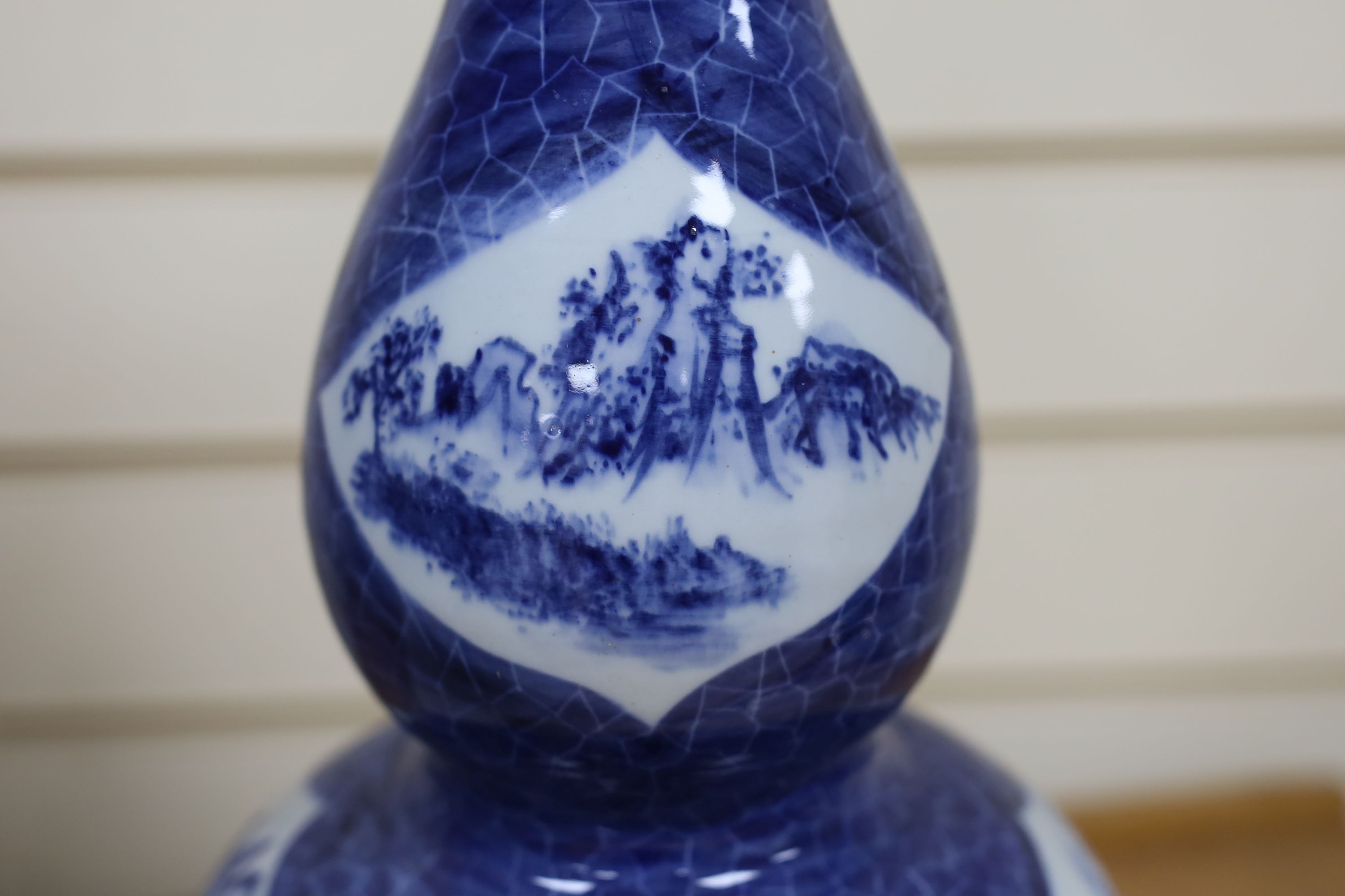 A Chinese blue and white gourd vase with landscape decoration, a similar blue and white sleeve vase and a Japanese Kutani vase